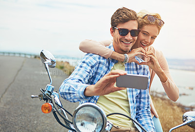 Buy stock photo Shot of a couple taking a selfie while out on a road trip with a scooter