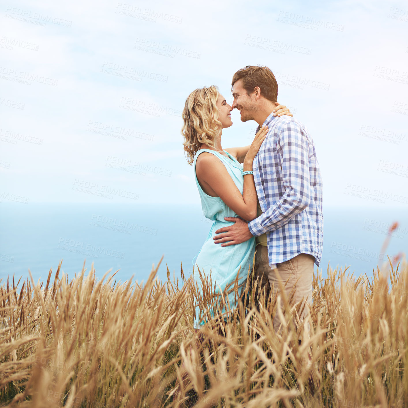 Buy stock photo Shot of a young couple in a field on a sunny day