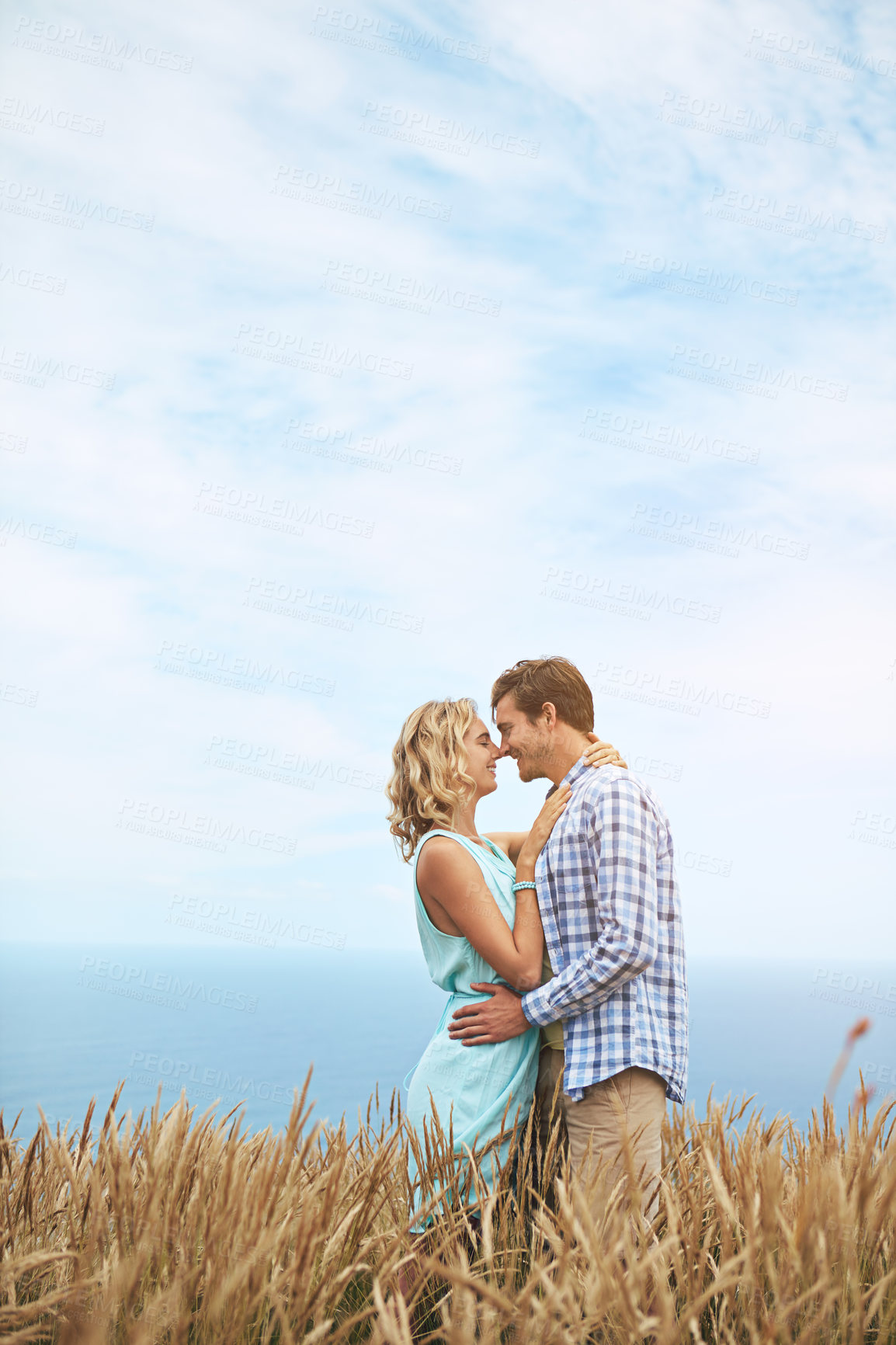 Buy stock photo Shot of a young couple in a field on a sunny day