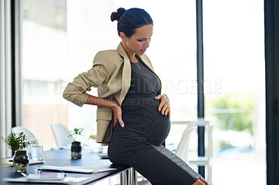 Buy stock photo Shot of a pregnant businesswoman in discomfort in her office