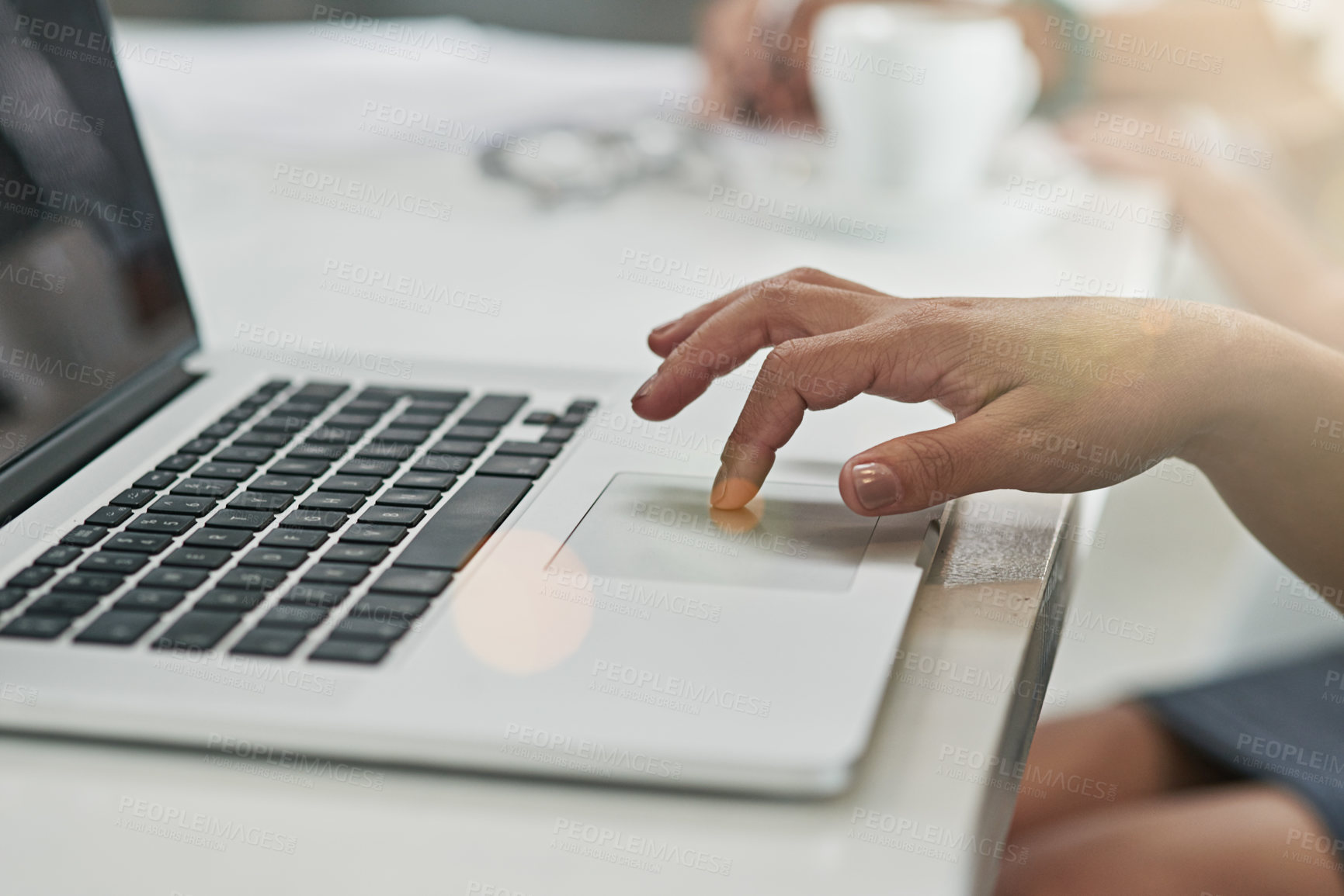 Buy stock photo Cropped shot of a woman using a laptop at her desk in an office