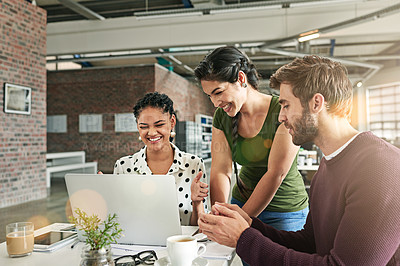 Buy stock photo Shot of a team of colleagues using a laptop together in a modern office