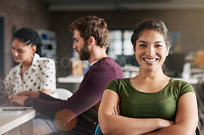 Buy stock photo Portrait of a successful young woman working in a modern office with her colleagues in the background
