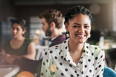 Buy stock photo Portrait of a successful young woman working in a modern office with her colleagues in the background