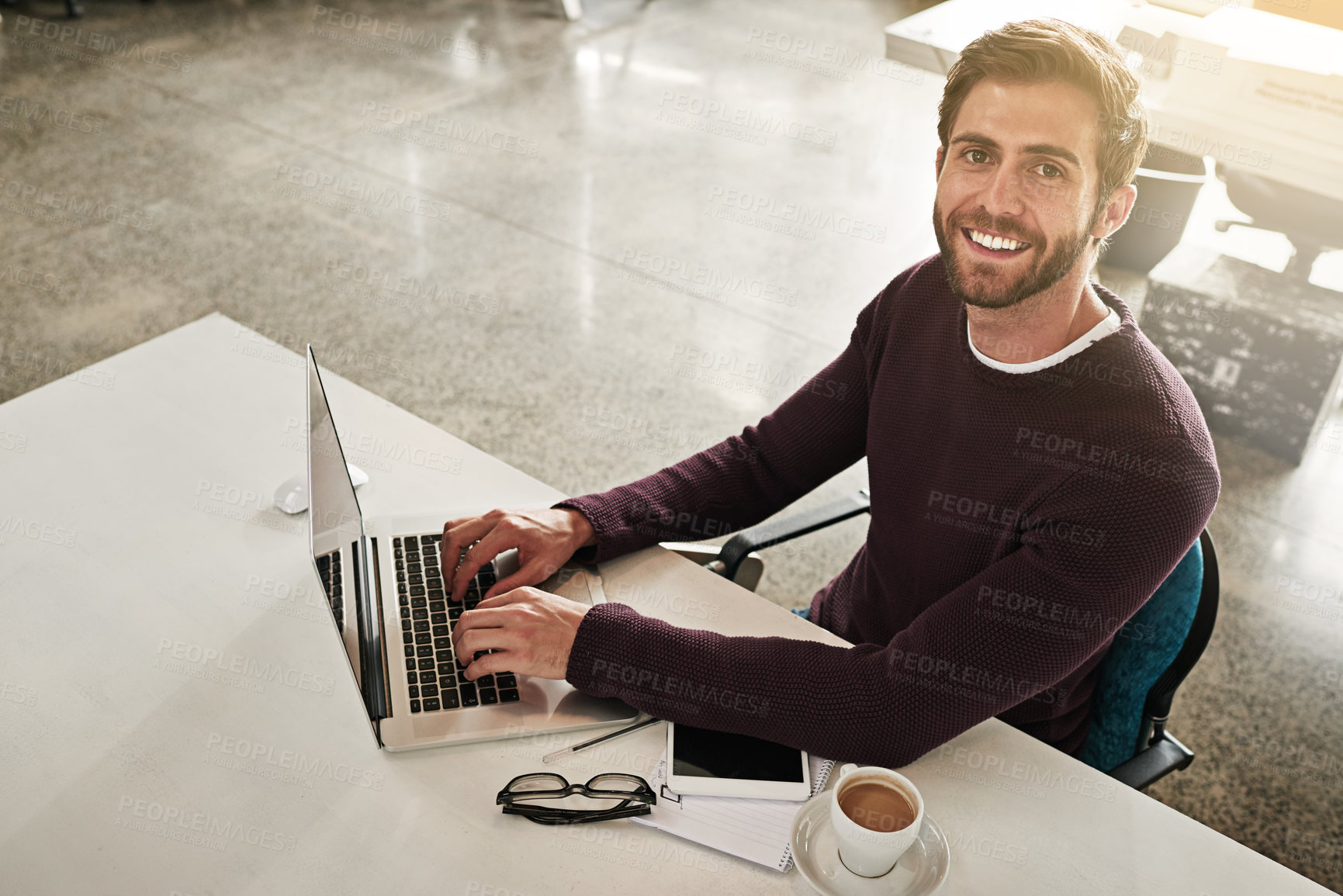 Buy stock photo Portrait of a young businessman working at his desk in a modern office