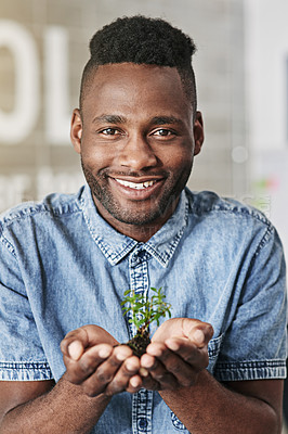 Buy stock photo Portrait of a young man holding a plant growing out of soil in a modern office