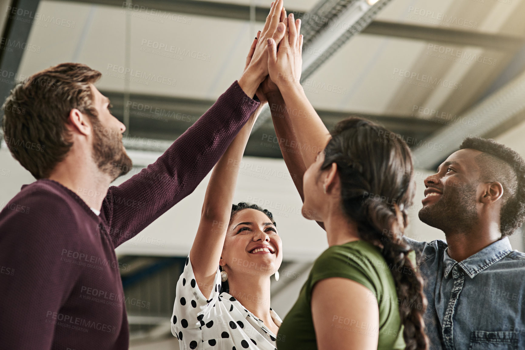 Buy stock photo Shot of a team of colleagues giving each other a high five in a modern office