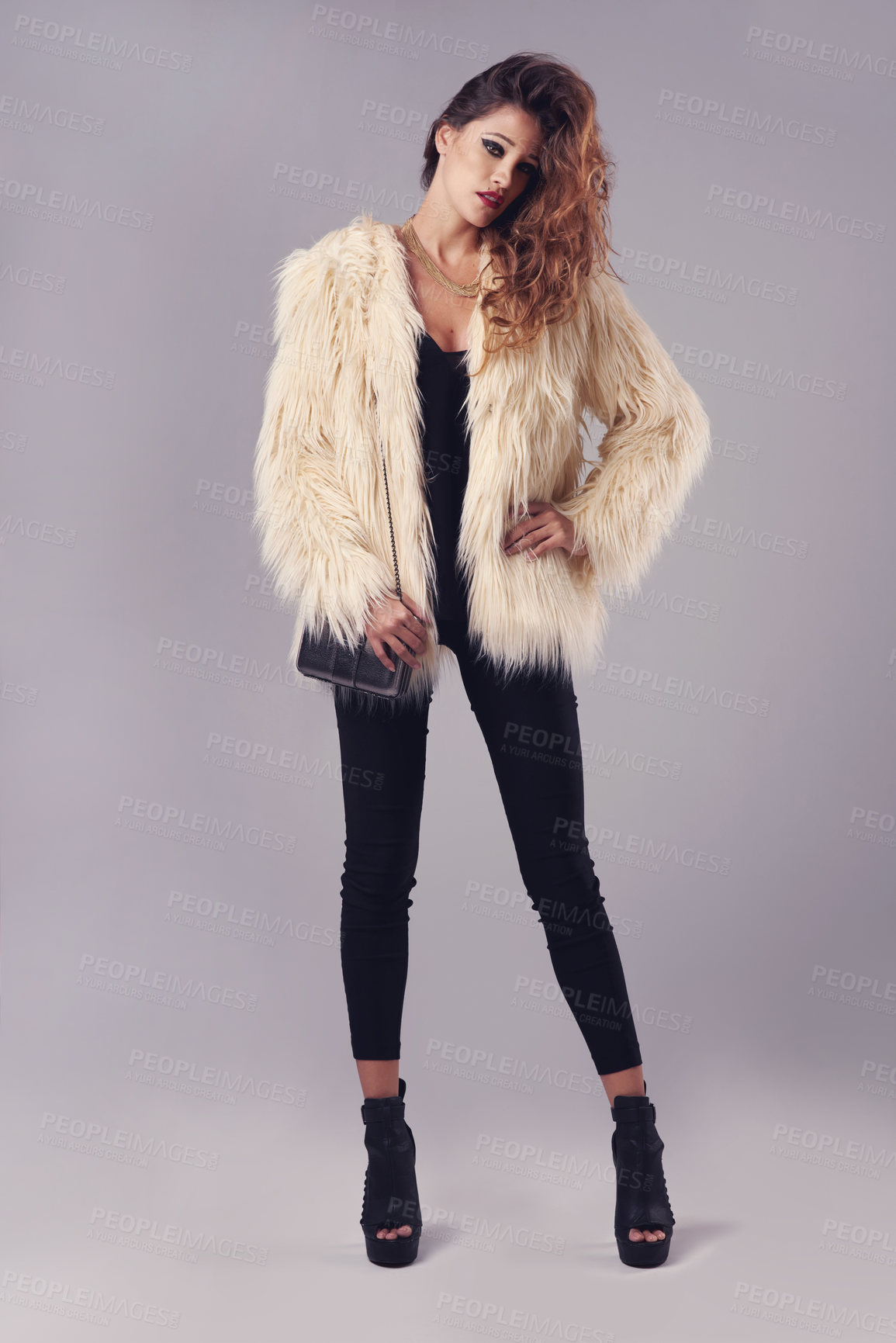 Buy stock photo Studio portrait of a young woman posing against a grey background