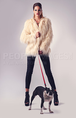 Buy stock photo Studio portrait of a young woman posing with her dog against a grey background