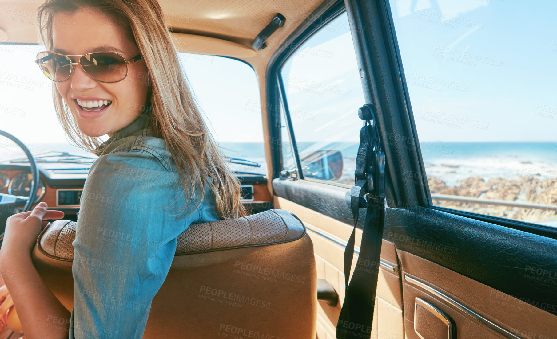 Buy stock photo Shot of a young woman on a road trip near the ocean