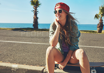 Buy stock photo Shot of a young woman hanging out on the boardwalk with her skateboard