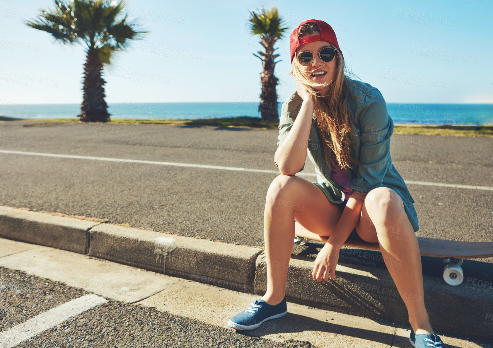 Buy stock photo Shot of a young woman hanging out on the boardwalk with her skateboard