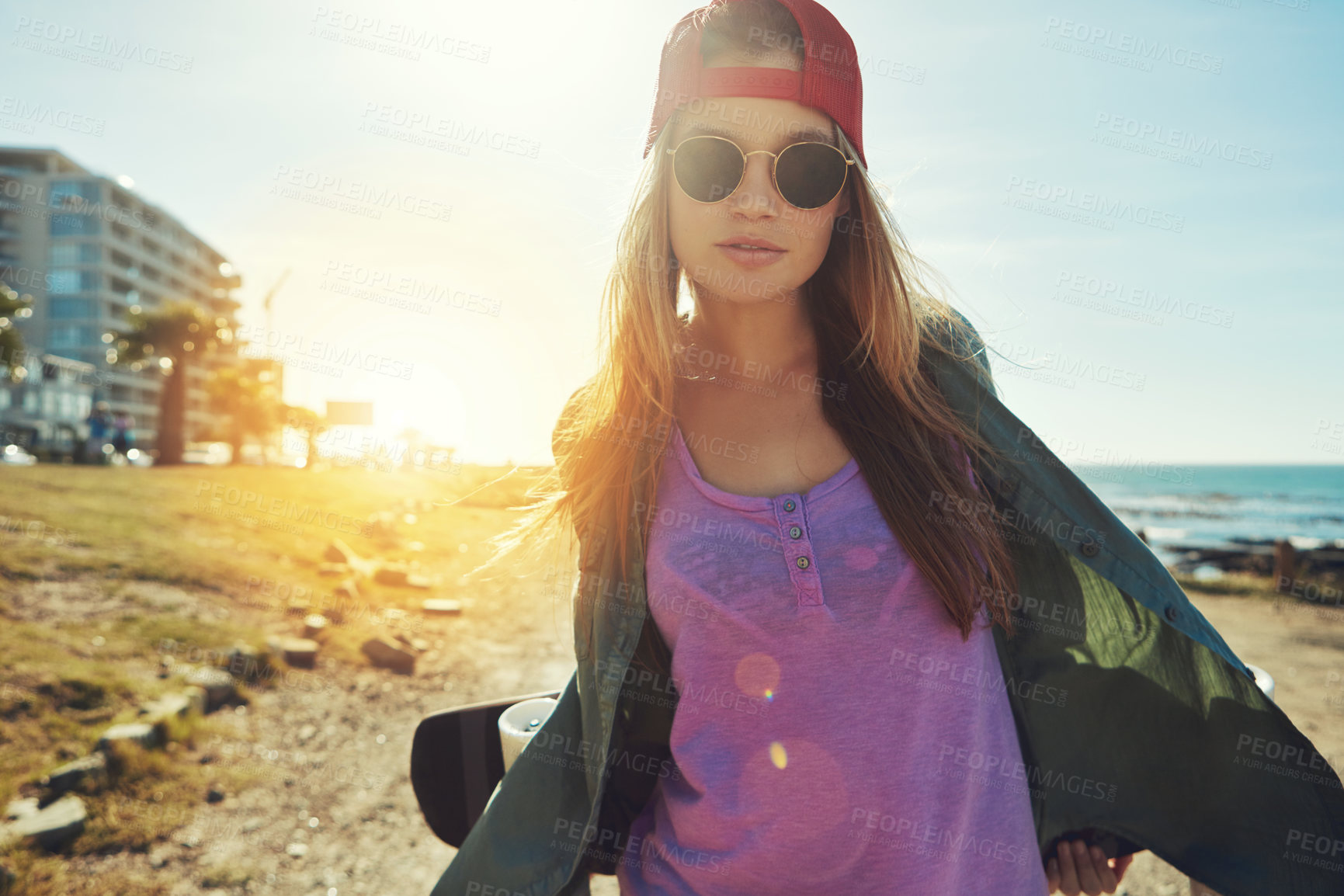 Buy stock photo Serious, skater or woman at beach in summer holiday, sunglasses, training outdoor and sport hobby. Portrait, sunshine or girl at ocean with board, physical activity or vacation skating at seaside