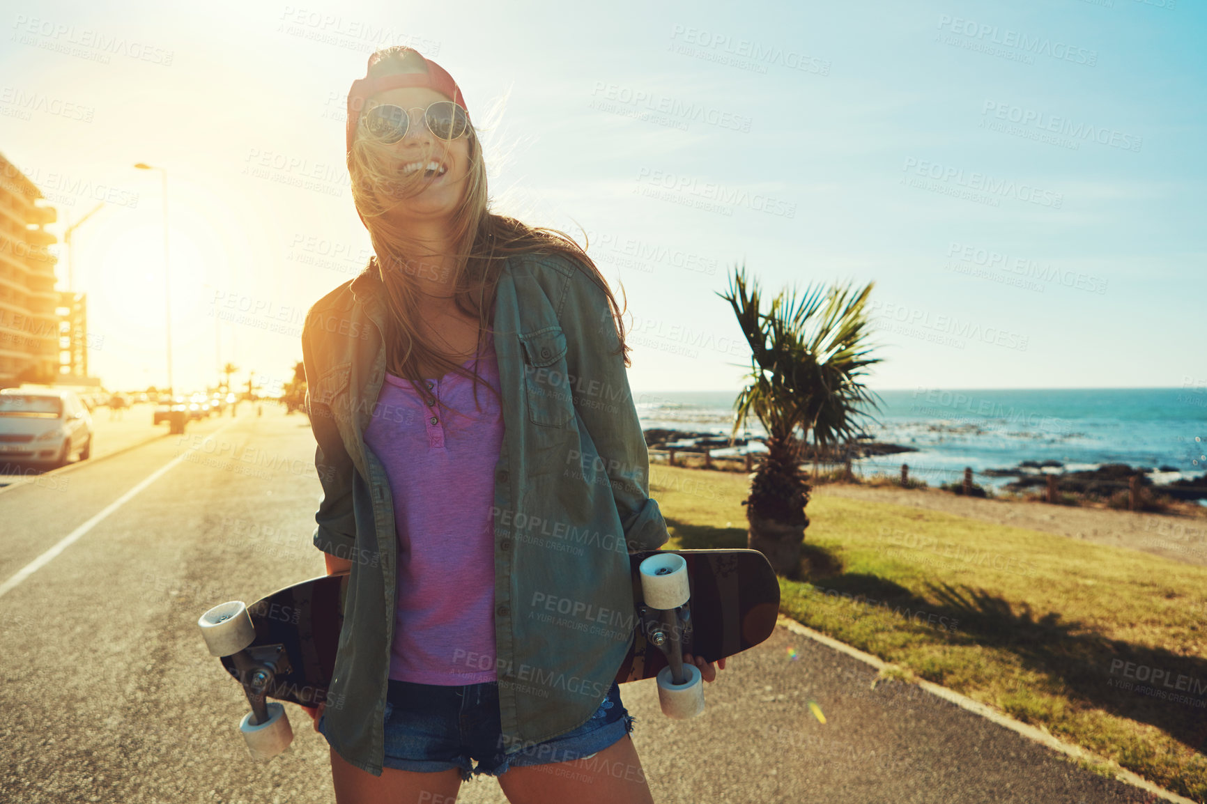 Buy stock photo Shot of a young woman hanging out on the boardwalk with her skateboard