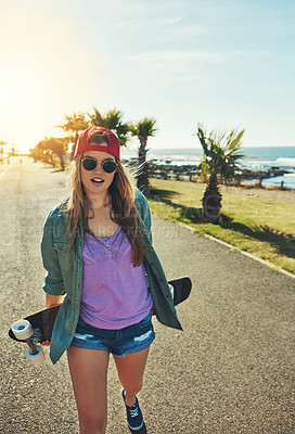 Buy stock photo Shot of a young woman hanging out on the boardwalk with a skateboard