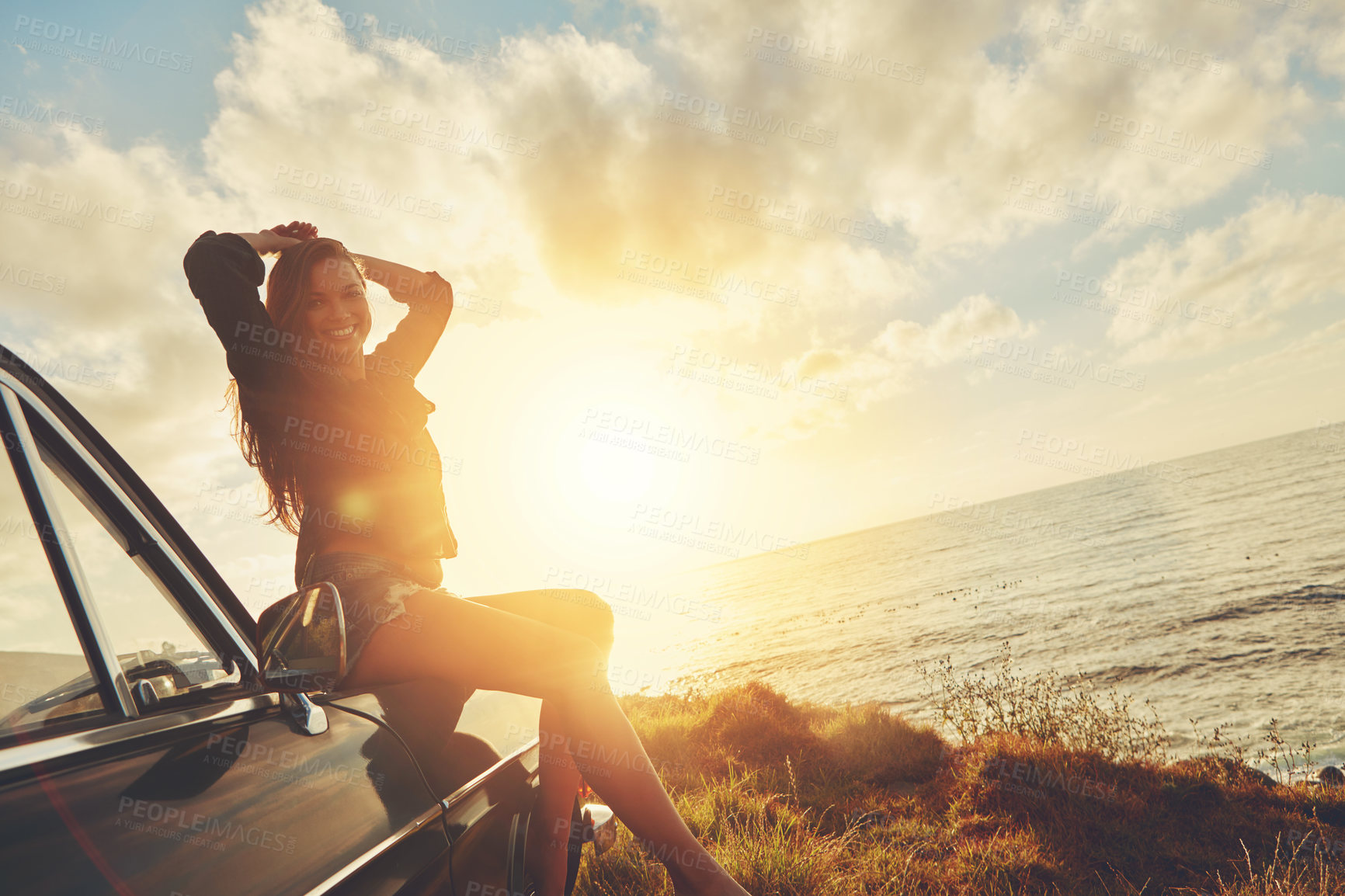 Buy stock photo Woman, sunset portrait and road trip on hood of car with smile, beach or happiness for summer vacation. Happy gen z girl, sky and sunshine with nature, outdoor adventure and holiday by ocean in Miami