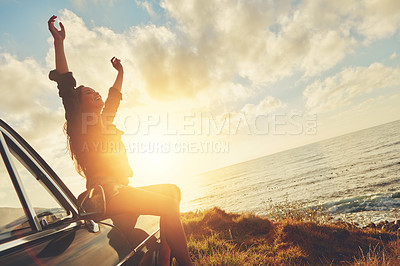 Buy stock photo Road trip, sunset and arms raised with a woman at the coast, sitting on her car bonnet during travel for freedom or escape. Nature, flare and water with a young female tourist traveling in summer