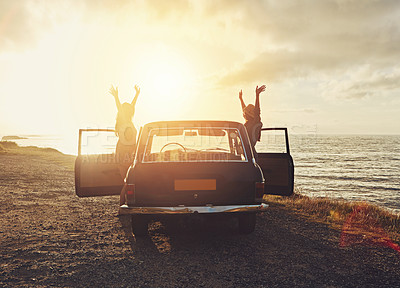 Buy stock photo Full length shot of two friends on a road trip to the beach at sunset