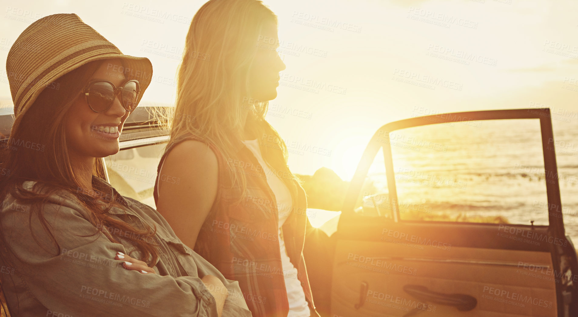 Buy stock photo Cropped shot of two friends on a road trip to the beach at sunset