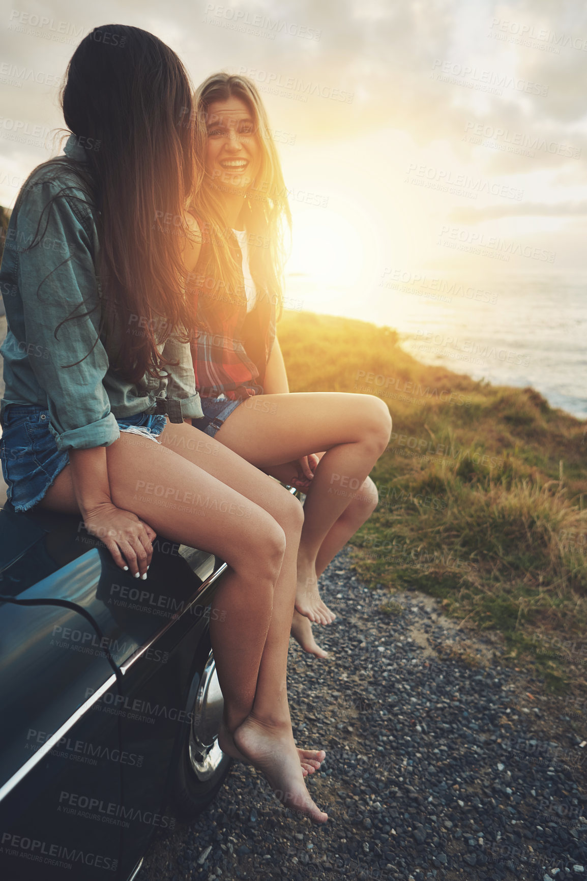 Buy stock photo Women friends, road trip and sunset in nature for travel, adventure and freedom while happy outdoor. Funny girls on a car while talking on vacation drive or journey with transport and ocean view 