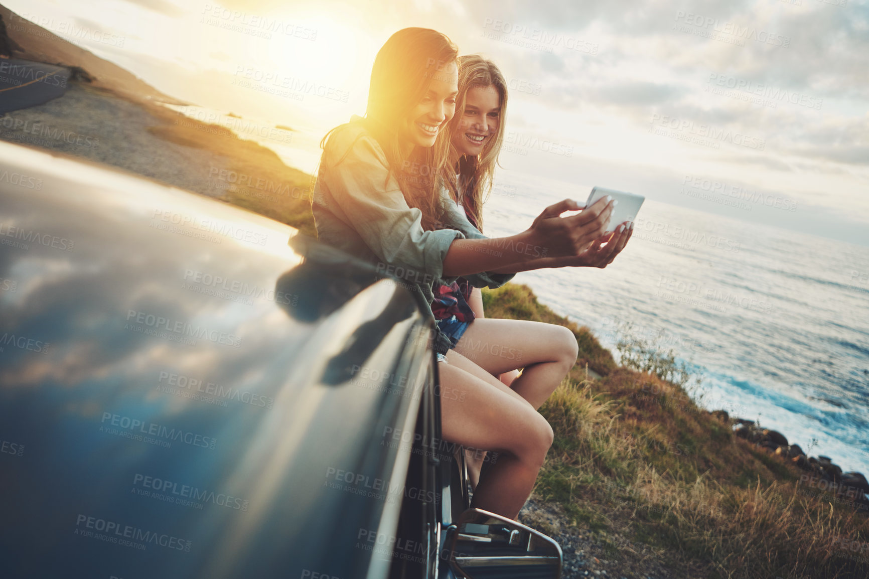 Buy stock photo Friends, women and selfie at beach for road trip and adventure in car for outdoor memory and holiday. Ocean travel, sunset or happy people in picture on fun summer vacation, photography or lens flare