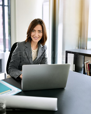 Buy stock photo Portrait of a successful businesswoman using a laptop at a desk in an office