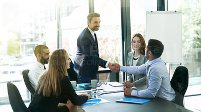 Buy stock photo Shot of colleagues shaking hands during a formal meeting in an office