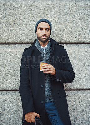 Buy stock photo Cropped shot of a fashionable young man leaning against a building in an urban setting