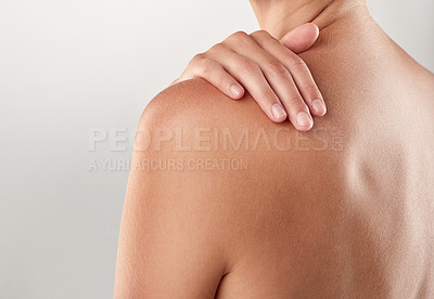 Buy stock photo Closeup studio shot of a woman touching her bare shoulder