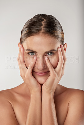 Buy stock photo Closeup studio portrait of a beautiful young woman touching her face