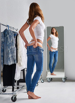 Buy stock photo Woman, mirror and trying on clothes in dressing room, retail store and shopping for jeans or denim pants. Thinking, customer fitting for choice in reflection, buying and sale for comfort in boutique