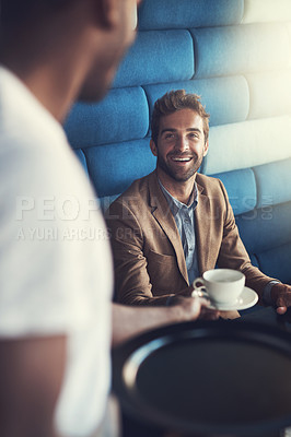 Buy stock photo Shot of a waiter serving his customer a beverage in a cafe