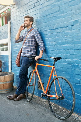 Buy stock photo Bike, phone call and smile with business man on blue wall in city for morning commute to work. Contact, thinking and transportation with happy young employee talking on mobile for communication