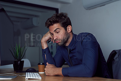 Buy stock photo Portrait of a tired looking young businessman sitting at his desk