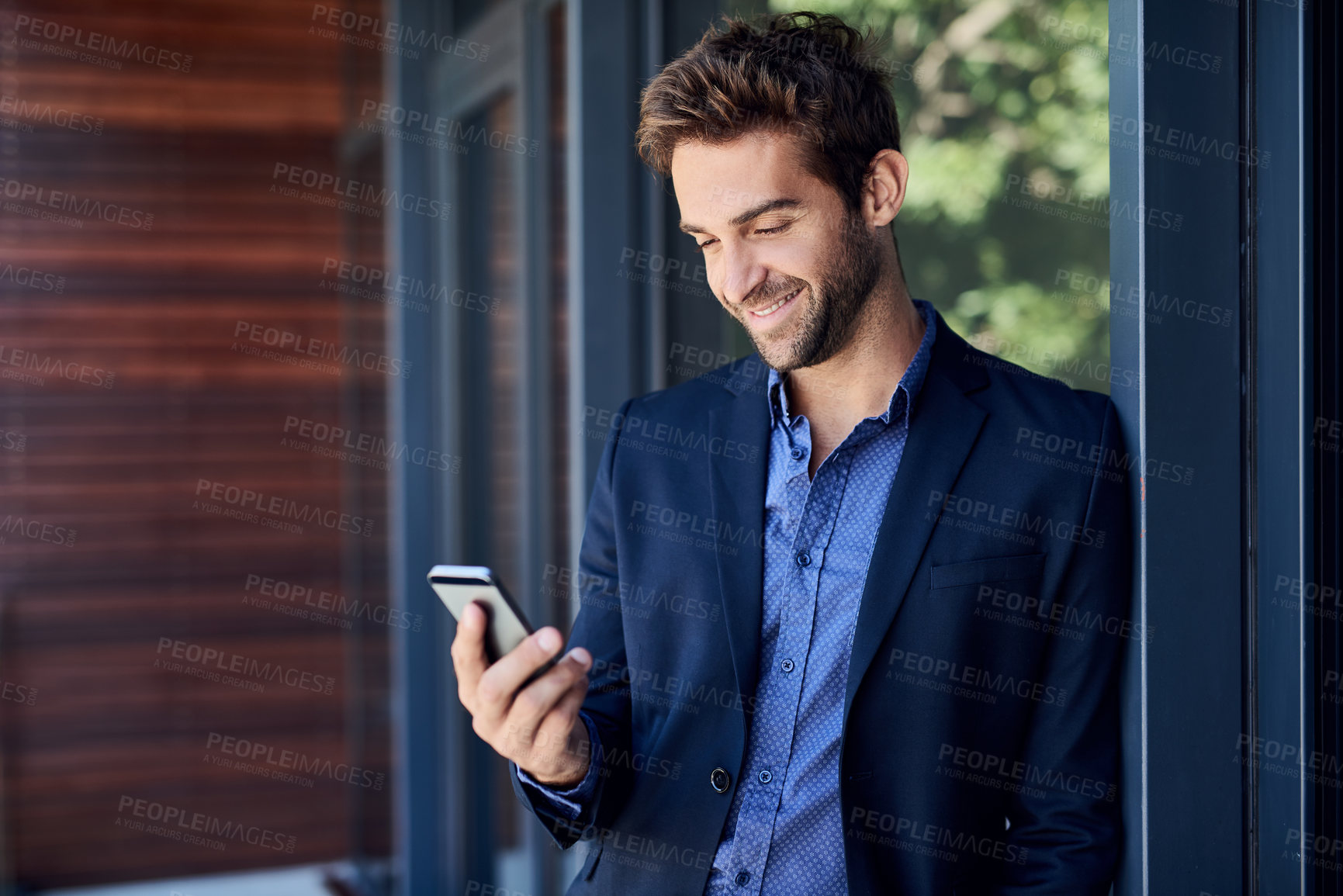 Buy stock photo Shot of a young businessman busy on the phone outside the office