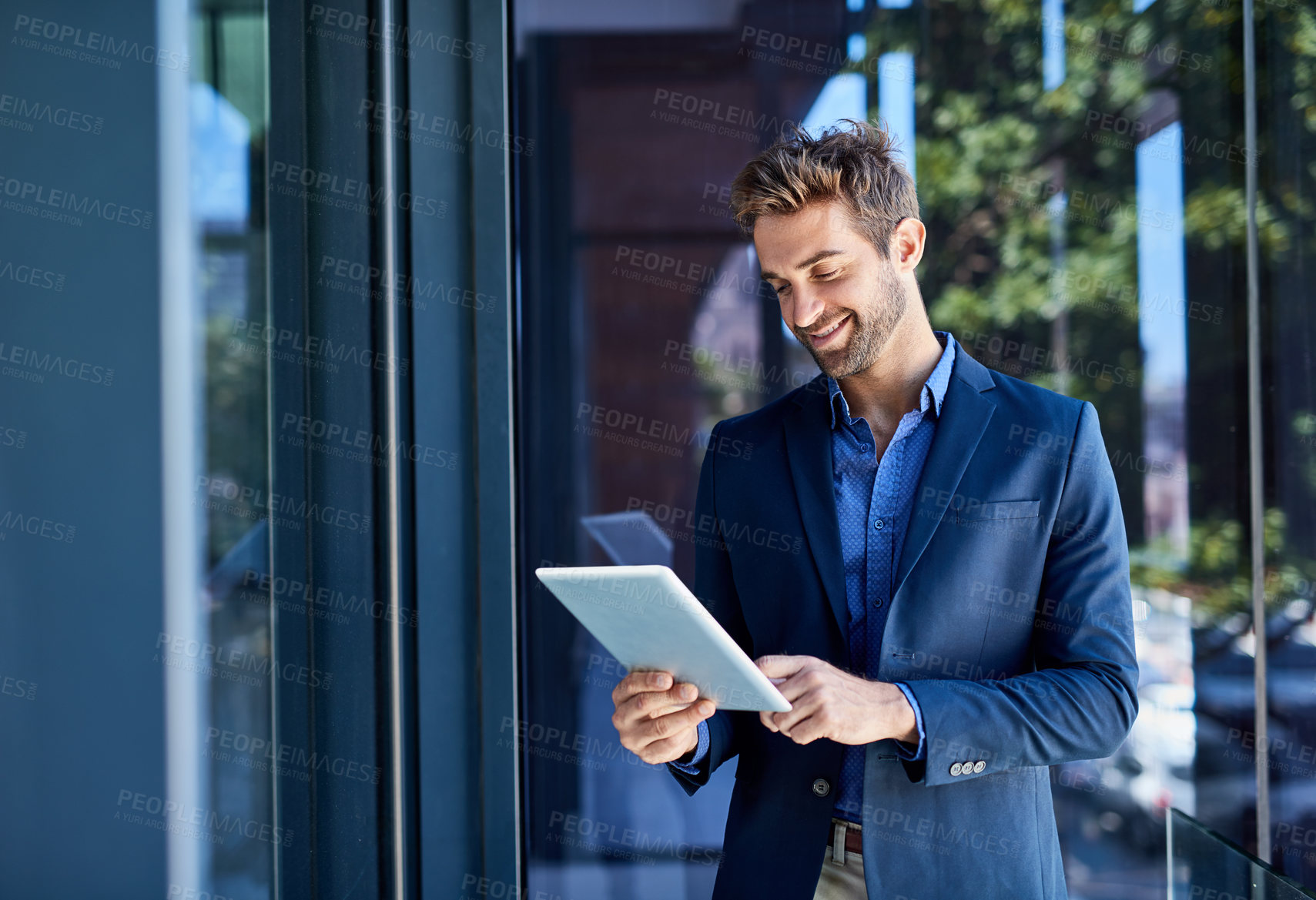 Buy stock photo Shot of a young businessman busy on a digital tablet