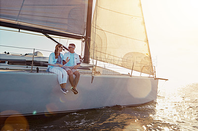 Buy stock photo Shot of a couple enjoying a boat cruise out on the ocean