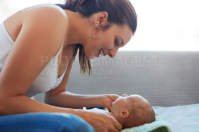 Buy stock photo Shot of a mother sitting with her newborn baby on a couch