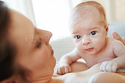 Buy stock photo Closeup shot of a mother lying down with her newborn baby on top of her