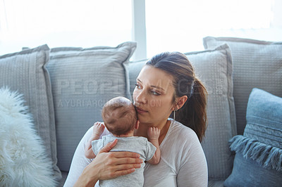 Buy stock photo Shot of a mother sitting with her newborn baby on a couch