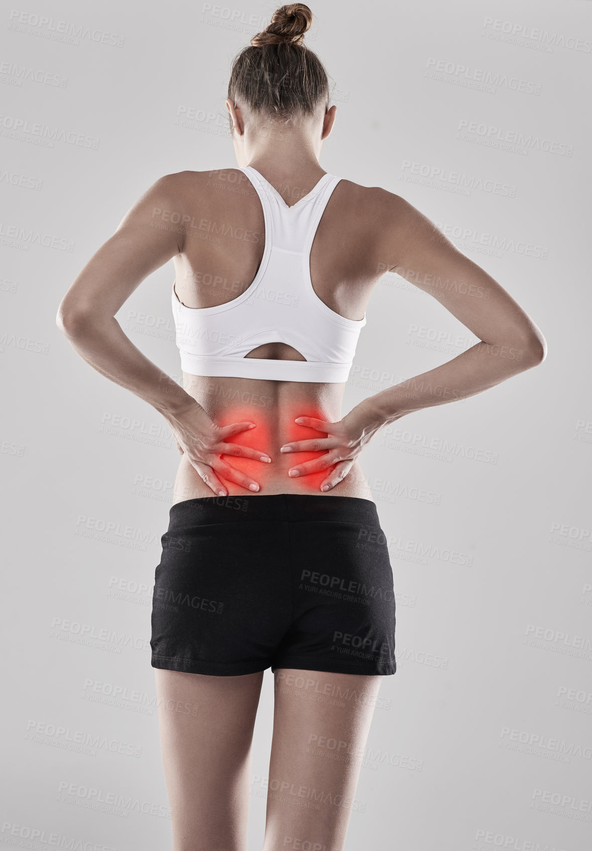 Buy stock photo Shot of a young woman holding her injured back that's highlighted in red