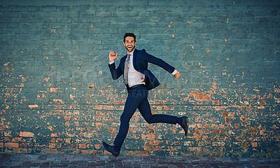 Buy stock photo Portrait of a young corporate businessman jumping midair against a brick wall
