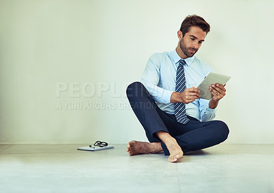 Buy stock photo Business, man and relax with tablet on floor for reading online from digital technology. Male person, sitting and wall by surfing internet, browsing and research on wireless tech at home on ground