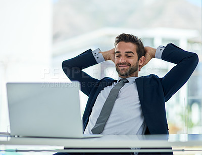 Buy stock photo Shot of a young corporate businessman taking a break at an office desk