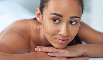 Buy stock photo Shot of a beautiful young woman relaxing on a massage table at a spa