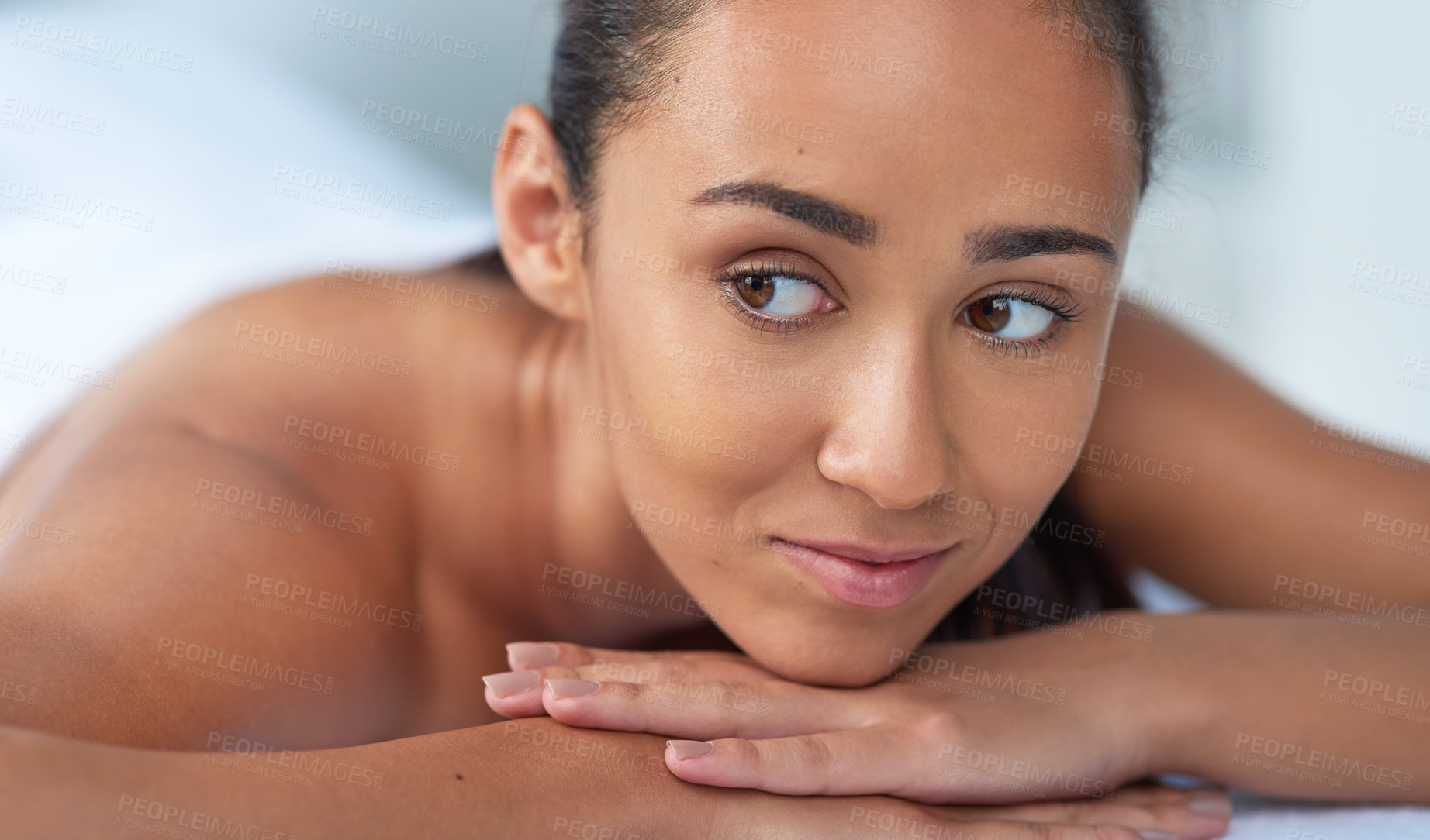 Buy stock photo Shot of a beautiful young woman relaxing on a massage table at a spa