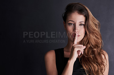 Buy stock photo Studio portrait of a seductive young woman posing against a dark background