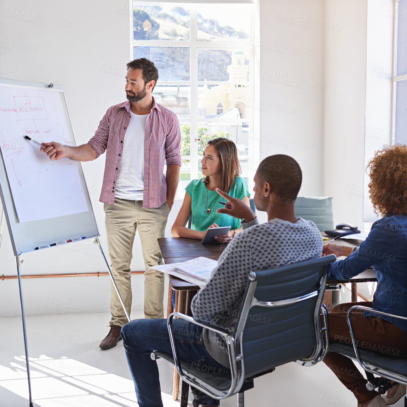 Buy stock photo Shot of a young businessman giving a presentation to his design team