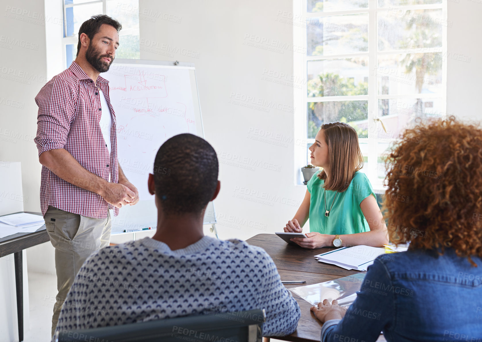 Buy stock photo Shot of a young businessman giving a presentation to his design team