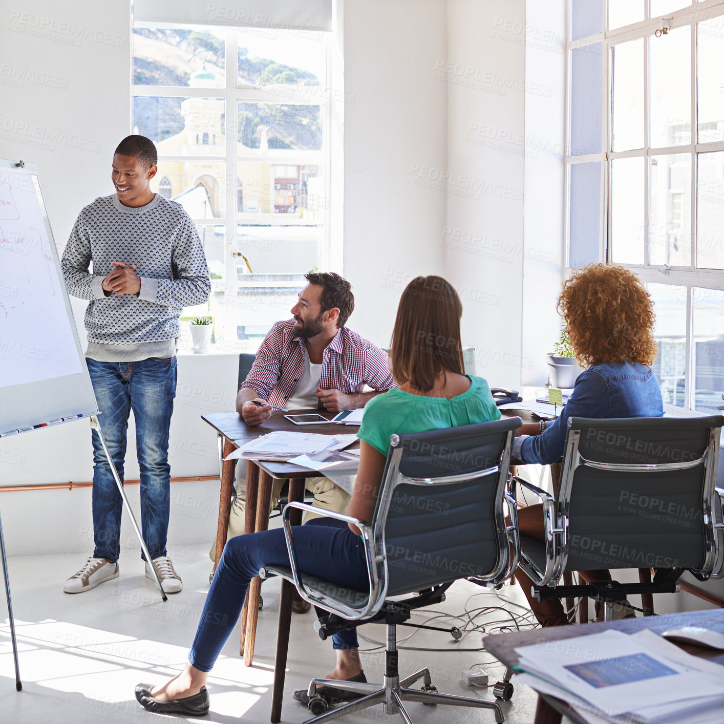 Buy stock photo Shot of a young businessman giving a presentation to his design team